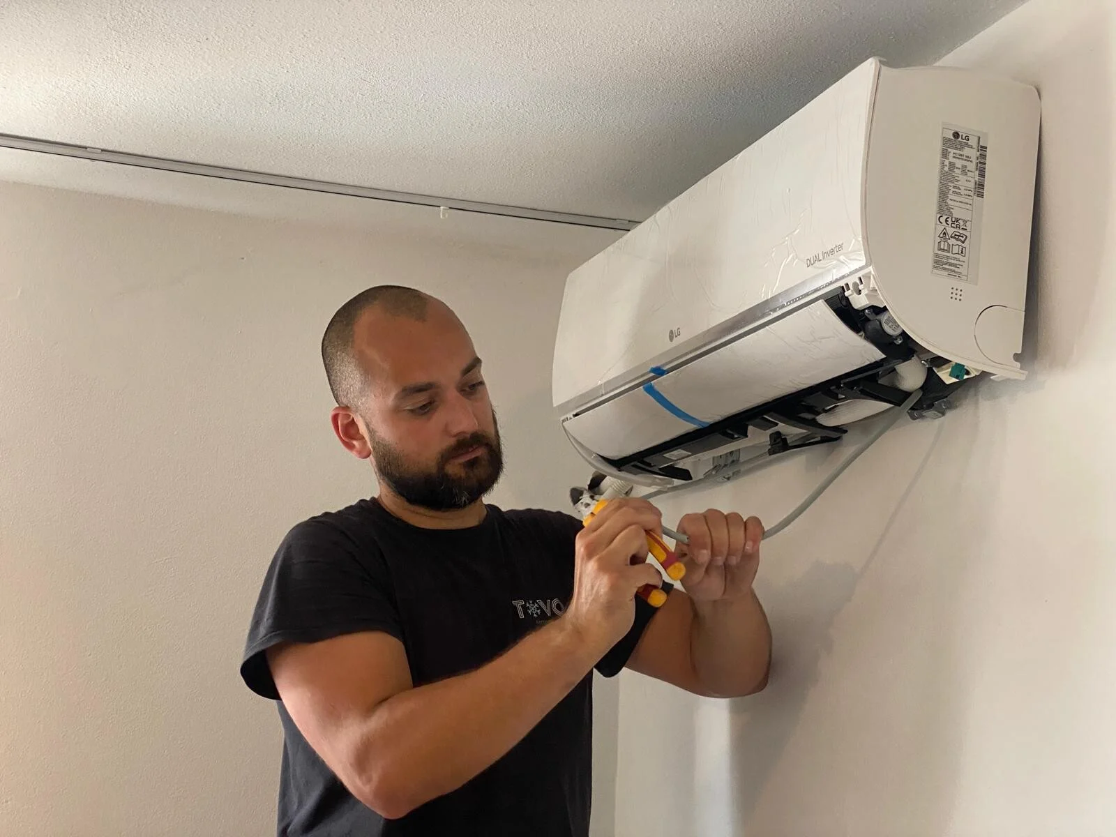 Tovomontage monteur installeert een LG airco binnenunit met precisie